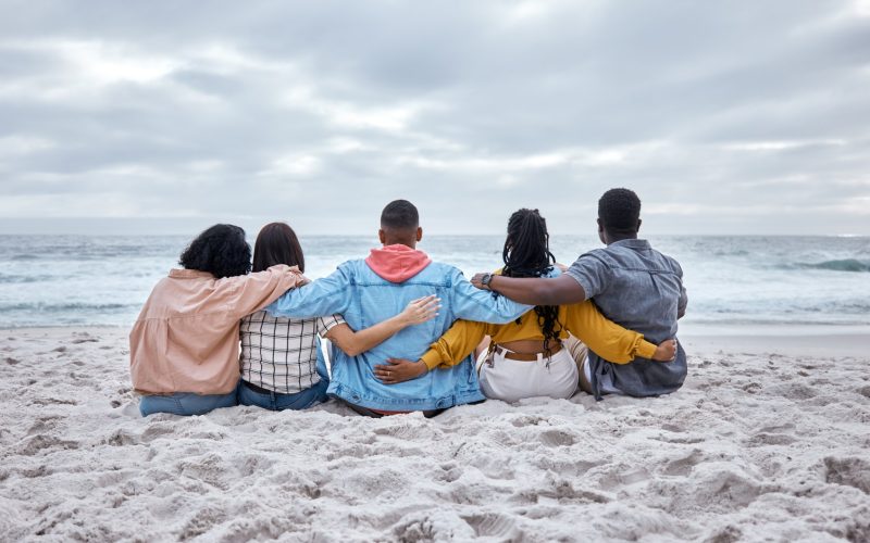 Diversity, hug or friends on beach sand to relax on calm holiday, vacation bonding in nature togeth.