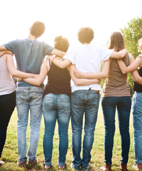 large group of friends holding each other in a late summer day